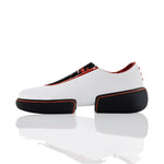 White sneakers with black and orange accents on a reflective surface